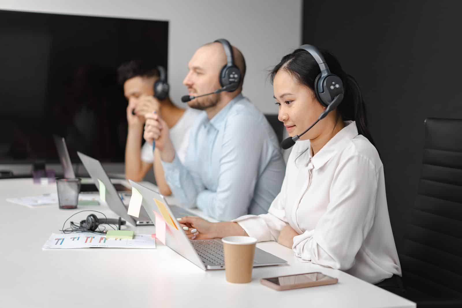 Support-Team mit Headsets bearbeitet Kundenanfragen